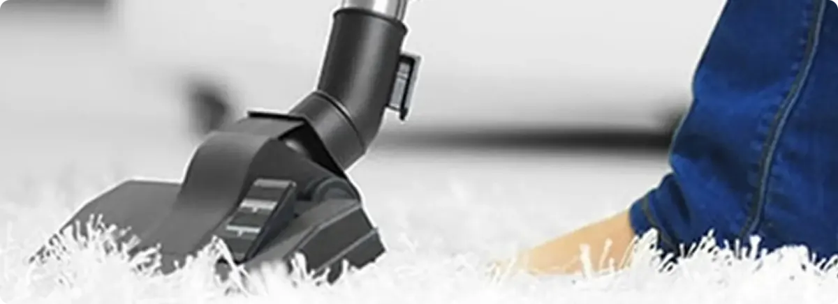 Close-up of a professional vacuuming a white carpet in Sammamish.
